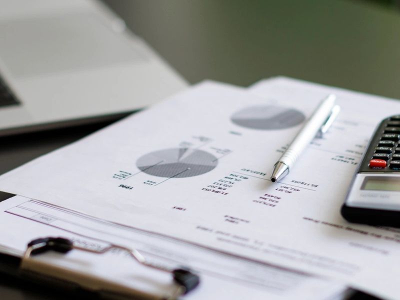 Financial pie charts and data sheets with silver pen